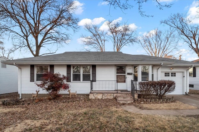 ranch-style house with concrete driveway, a porch, and an attached garage