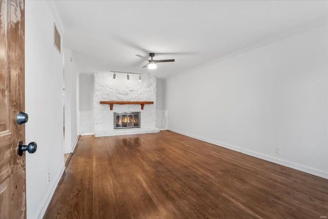 unfurnished living room with a fireplace, wood finished floors, visible vents, a ceiling fan, and crown molding