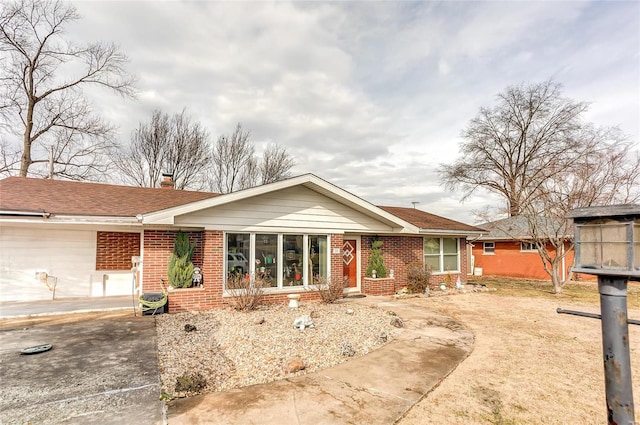 ranch-style house featuring brick siding and a chimney