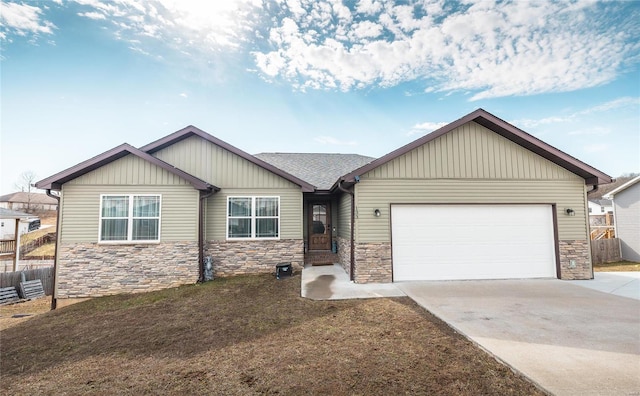 view of front of home with an attached garage, stone siding, fence, and concrete driveway