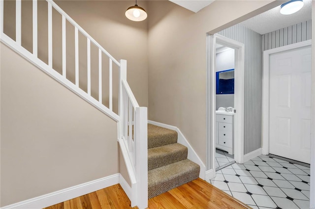 entryway featuring baseboards, stairway, and wallpapered walls