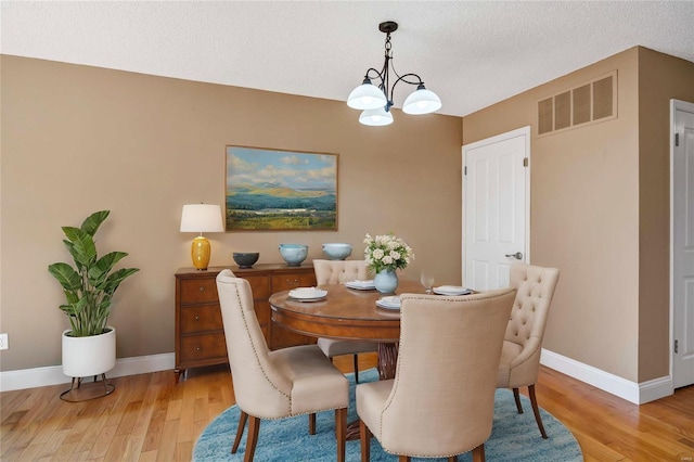 dining space with baseboards, visible vents, and light wood-style floors