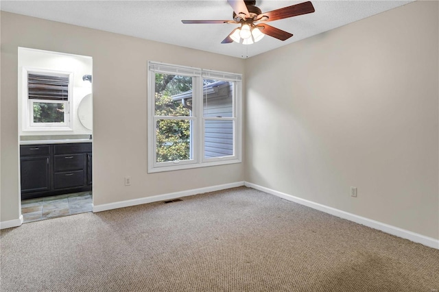 unfurnished room featuring a textured ceiling, visible vents, a ceiling fan, baseboards, and carpet