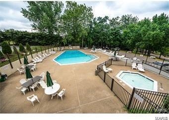 community pool featuring a patio area and fence