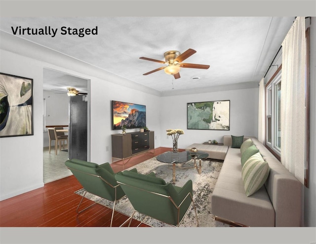 living area with a ceiling fan and wood finished floors