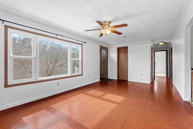 unfurnished room featuring hardwood / wood-style flooring, baseboards, and a ceiling fan