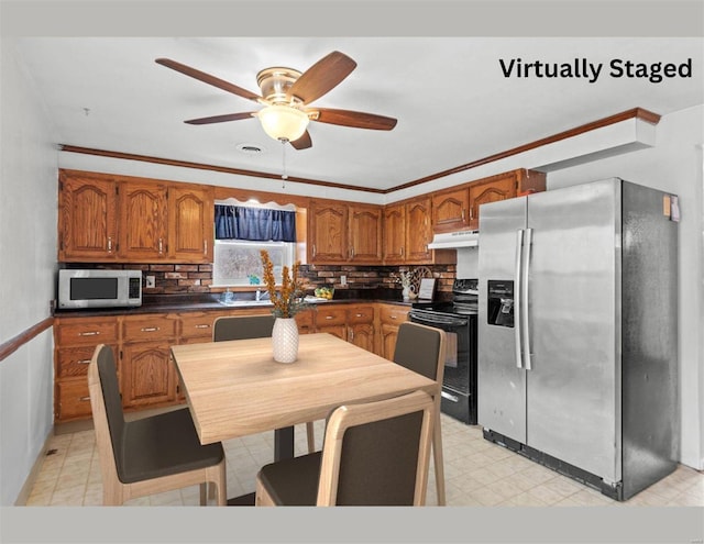 kitchen with stainless steel appliances, dark countertops, brown cabinets, and under cabinet range hood