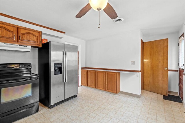 kitchen featuring black / electric stove, under cabinet range hood, visible vents, brown cabinets, and stainless steel fridge