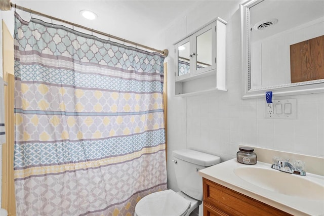 bathroom featuring tile walls, visible vents, backsplash, toilet, and vanity