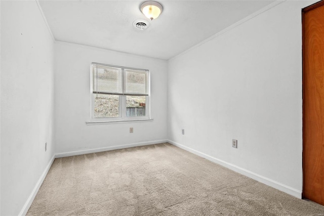 carpeted empty room with baseboards, visible vents, and ornamental molding