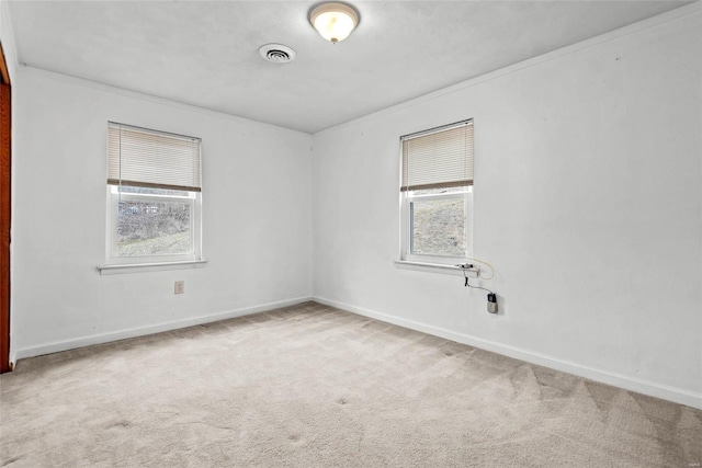 carpeted spare room featuring visible vents and baseboards