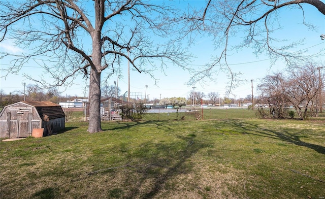 view of yard with a storage shed, fence, and an outdoor structure