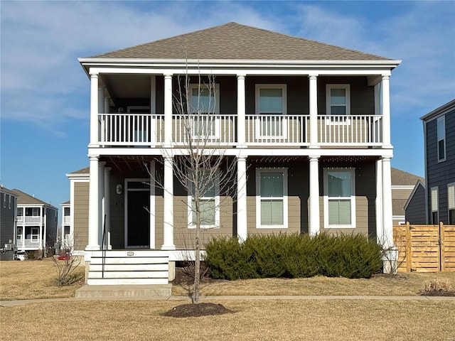 view of front of property featuring roof with shingles and fence