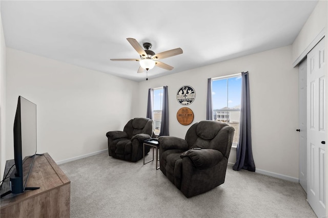 sitting room featuring carpet floors, a ceiling fan, and baseboards