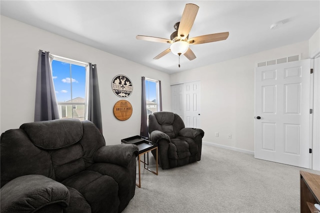 living area featuring light carpet, ceiling fan, visible vents, and baseboards