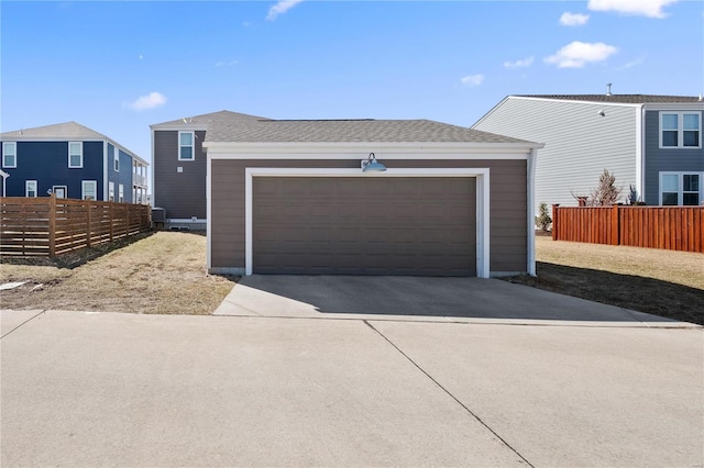 view of front of home with a garage, a shingled roof, and fence