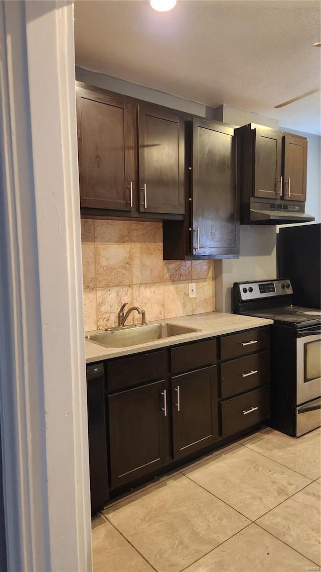 kitchen featuring electric stove, light countertops, decorative backsplash, a sink, and under cabinet range hood