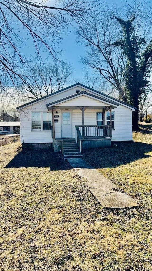 view of front of home with a front yard and covered porch