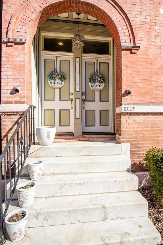 view of exterior entry featuring brick siding