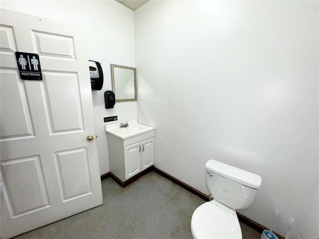 bathroom with baseboards, vanity, and toilet