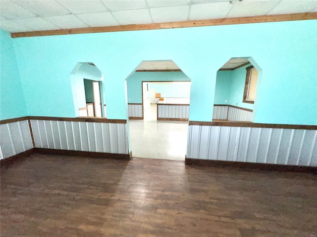 unfurnished room with a paneled ceiling and wood finished floors