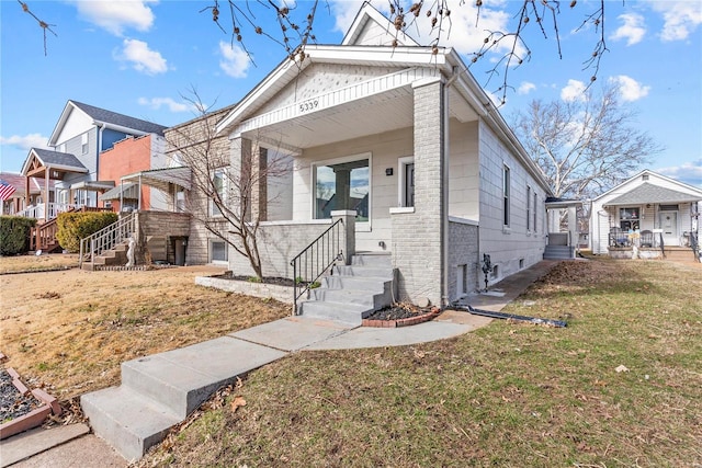 view of front of home featuring brick siding and a front lawn