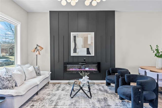 living area featuring wood finished floors and a glass covered fireplace