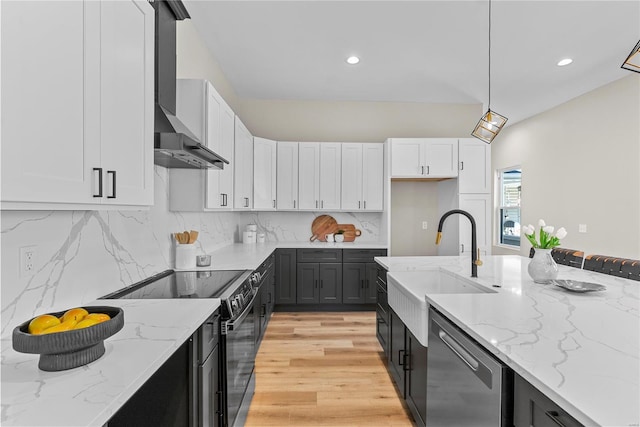 kitchen featuring black electric range oven, stainless steel dishwasher, white cabinets, a sink, and wall chimney exhaust hood