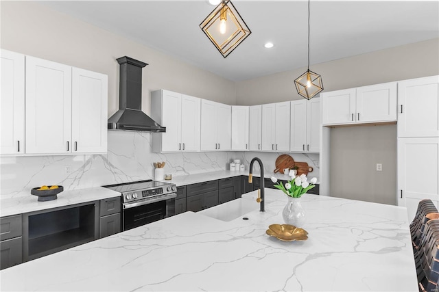 kitchen with electric stove, hanging light fixtures, decorative backsplash, a sink, and wall chimney range hood