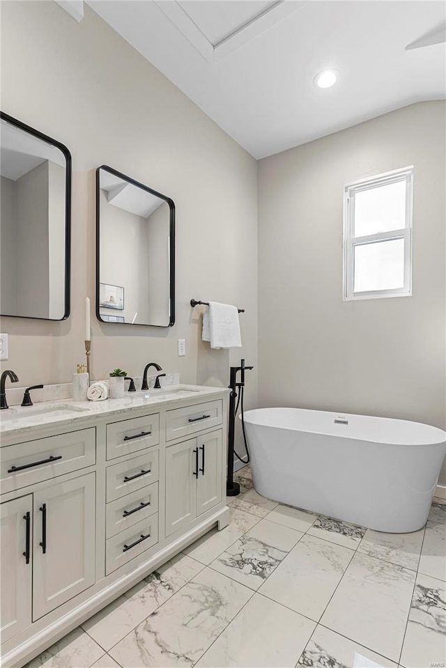 full bathroom featuring recessed lighting, a sink, marble finish floor, a soaking tub, and double vanity