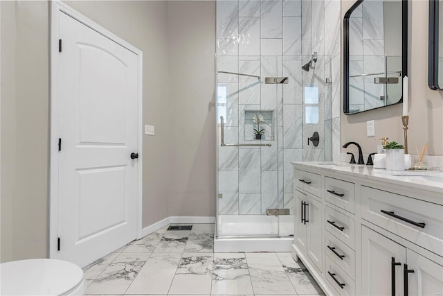 full bathroom with marble finish floor, double vanity, a stall shower, a sink, and baseboards