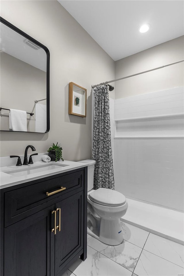 full bathroom with toilet, marble finish floor, tiled shower, and vanity