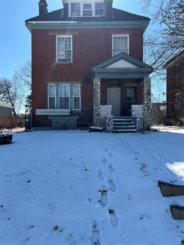 american foursquare style home featuring a chimney