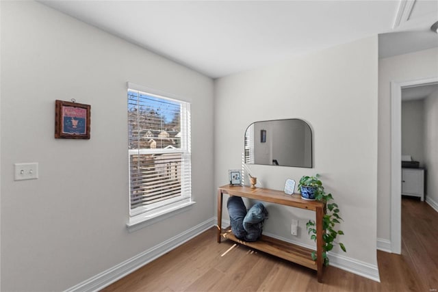 hall with baseboards and wood finished floors