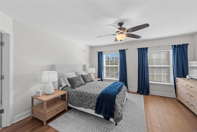 bedroom with visible vents, ceiling fan, light wood-style flooring, and baseboards