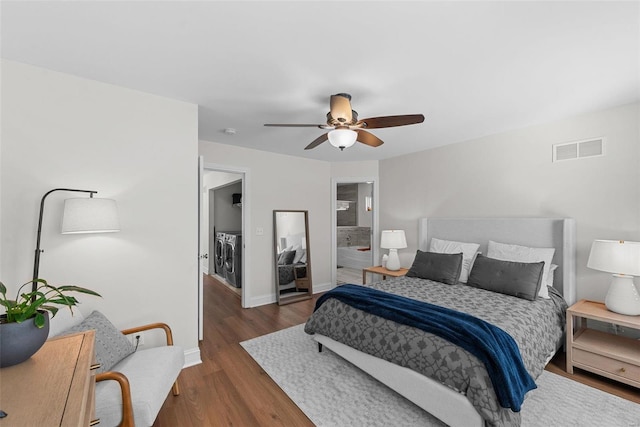 bedroom with baseboards, visible vents, a ceiling fan, dark wood-type flooring, and separate washer and dryer