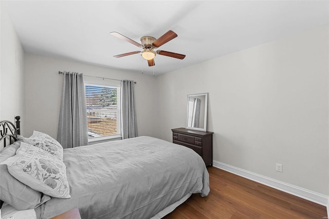 bedroom featuring ceiling fan, wood finished floors, and baseboards