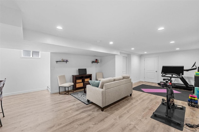 living room featuring baseboards, light wood-style flooring, visible vents, and recessed lighting