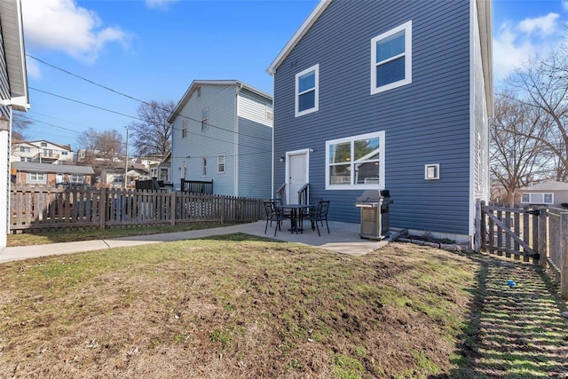 rear view of property with a patio area, a fenced backyard, and a yard