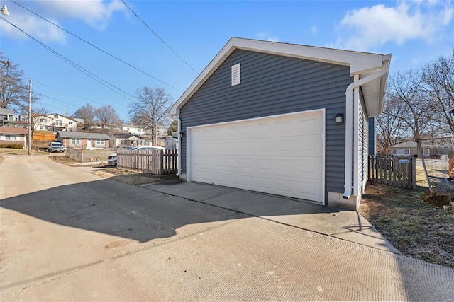 detached garage featuring a residential view and fence