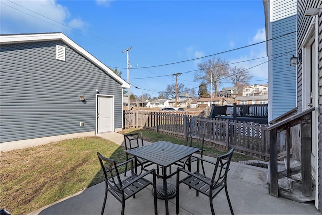 view of patio featuring a residential view, fence, and outdoor dining space