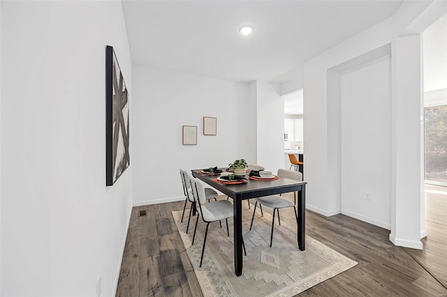 dining room featuring baseboards and dark wood-type flooring