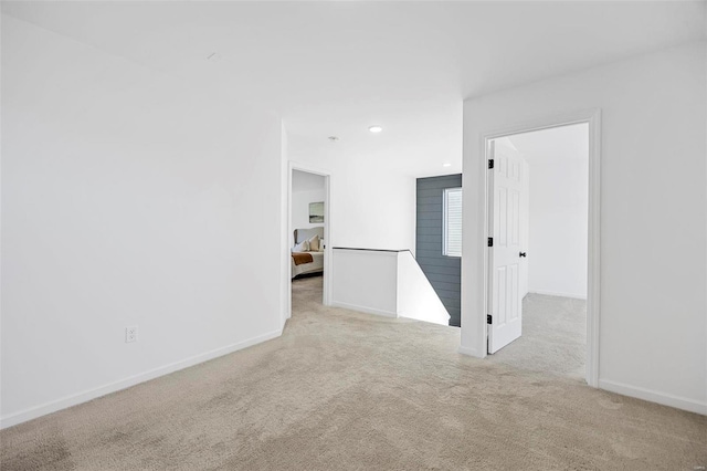 carpeted spare room featuring baseboards and recessed lighting