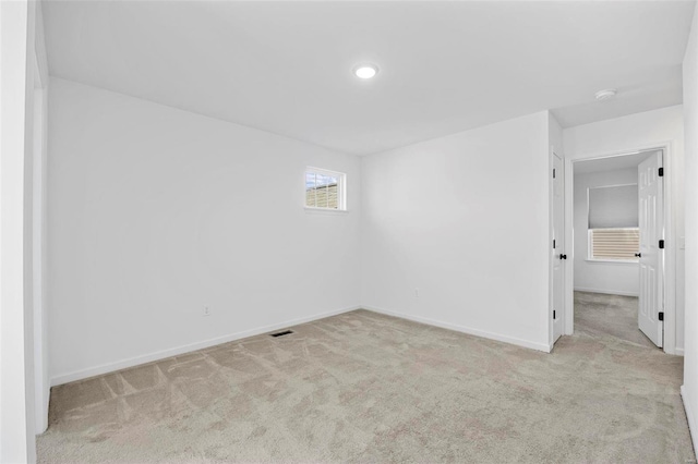 carpeted spare room with visible vents and baseboards