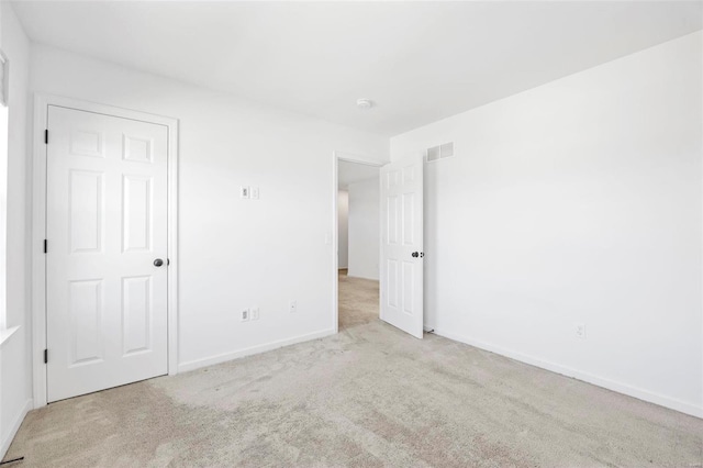 unfurnished bedroom featuring carpet, visible vents, and baseboards