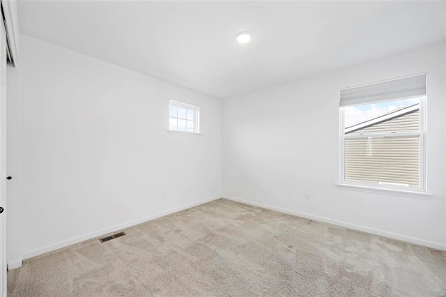 carpeted empty room with baseboards and visible vents