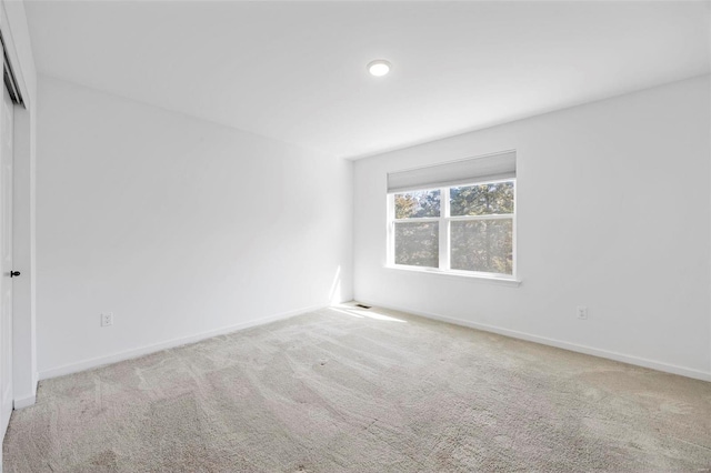 spare room featuring baseboards and carpet flooring