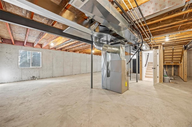 unfinished basement with visible vents and heating unit