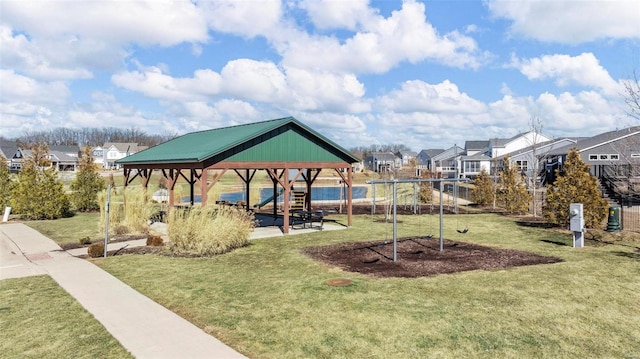 view of property's community featuring a yard, a residential view, playground community, and a gazebo