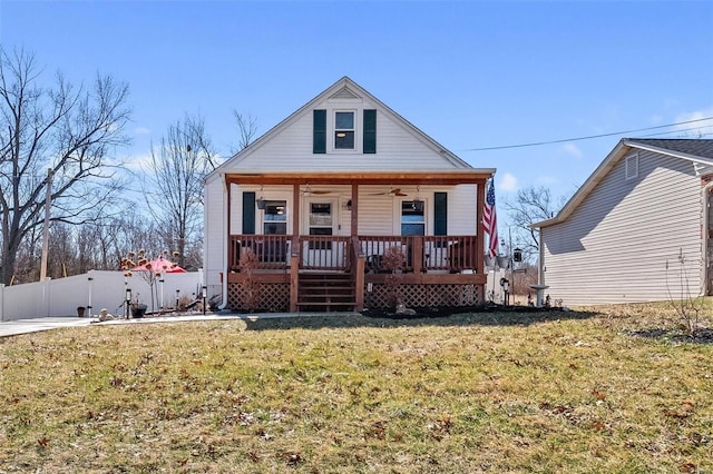 bungalow with a porch, a front yard, fence, and ceiling fan